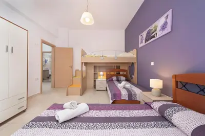 a bedroom with two beds and a bunk bed at Kiriakos Apartment in Afantou