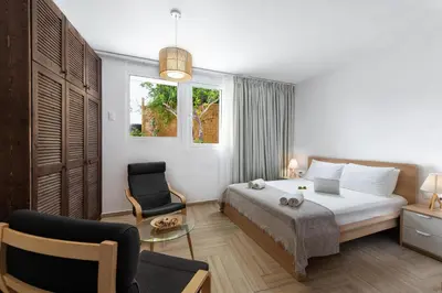 a bedroom with a bed and a chair and a window at Stegna Dream in Archangelos
