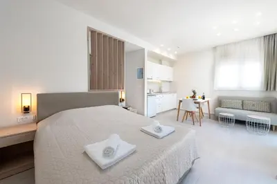 a white bedroom with a large bed with two white towels at Stegna Dream in Archangelos