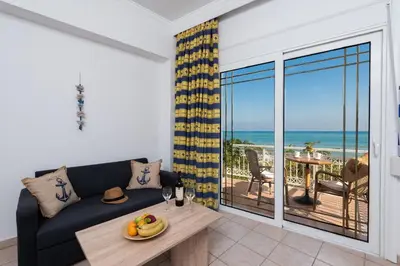 a living room with a couch and a view of the ocean at Stegna Dream in Archangelos