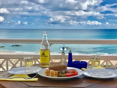 a table with two plates of food and a bottle of wine at Stegna Dream in Archangelos