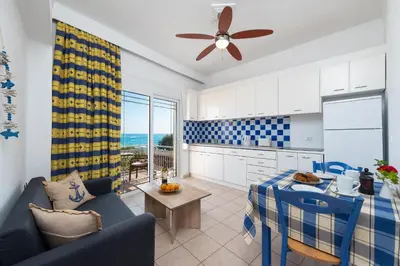 a kitchen and living room with a couch and a table at Stegna Dream in Archangelos