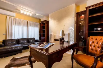 a living room with a table and a leather couch at Lindos Villa Estelle in Líndos