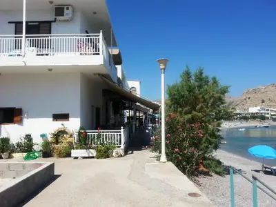 a building with a street light next to a body of water at Stamatia's House in Haraki