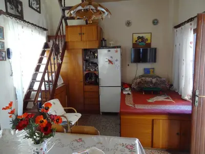 a kitchen with a refrigerator and a staircase in a room at Stamatia's House in Haraki