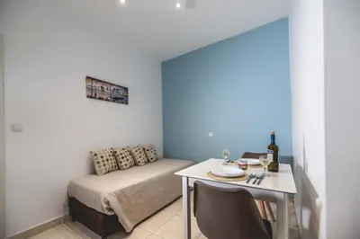 a small room with a bed and a table with a tableablish at Stegna Bay Apartment in Archangelos