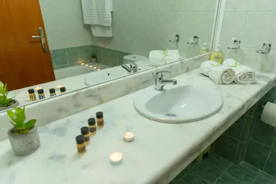 a bathroom counter with a sink and a mirror at Stegna Bay Apartment in Archangelos