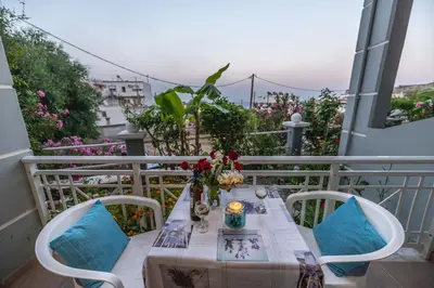 a table and chairs on a balcony with a view at Stegna Bay Apartment in Archangelos