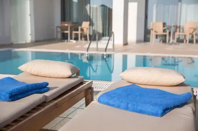 two beds sitting next to a swimming pool at Asterias Beach Resort in Afantou