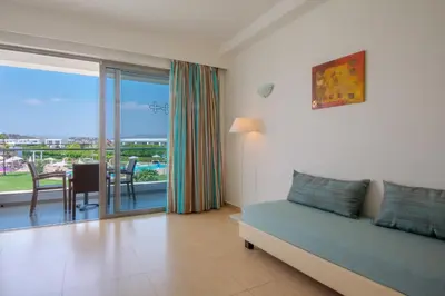 a living room with a couch and a table with a view at Asterias Beach Resort in Afantou