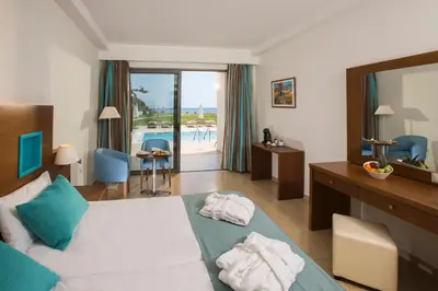 a hotel room with a bed and a mirror at Asterias Beach Resort in Afantou