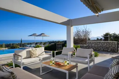 a patio with chairs and a table with a view at Kokinogremos Villa in Kalithies