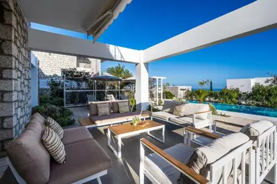 an outdoor patio with couches and a table at Kokinogremos Villa in Kalithies