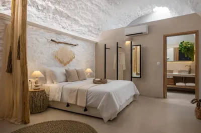 a bedroom with a large bed and a bathroom at Kaminos Boutique Hotel in Symi