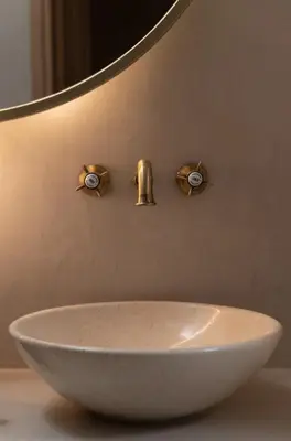 a bathroom sink with three knobs on the wall at Kaminos Boutique Hotel in Symi