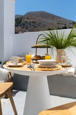 a white table with food and drinks on it at Kaminos Boutique Hotel in Symi