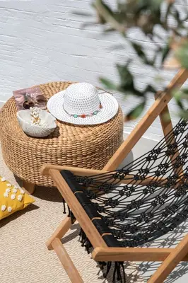 a rattan chair with a table with a hat and a rattan rattan at Kaminos Boutique Hotel in Symi