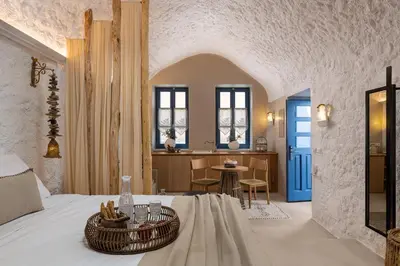 a bedroom with a bed and a table with chairs at Kaminos Boutique Hotel in Symi