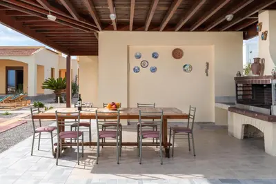 a patio with a wooden table and chairs at Villa Rose in Kolimbia