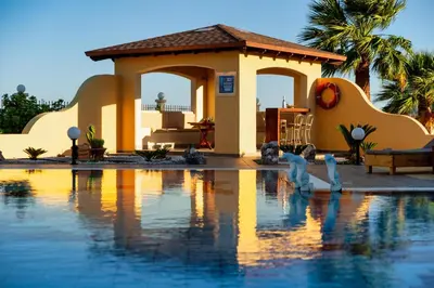 a villa with a swimming pool in front of a house at Villa Rose in Kolimbia