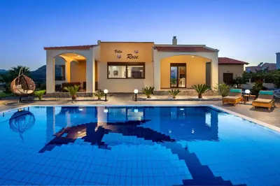 a large swimming pool in front of a house at Villa Rose in Kolimbia