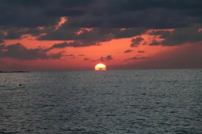 a sunset over the ocean with the sun in the horizon at Nikos Studios Meltemi Family Suite Penthouse in Archangelos