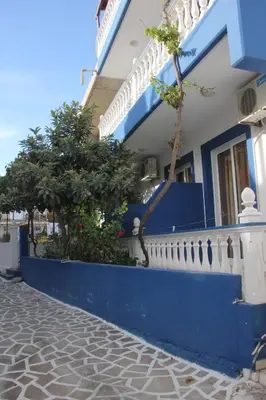 a blue and white building with a blue wall at Nikos Studios Meltemi Family Suite Penthouse in Archangelos