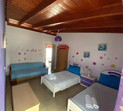 a bedroom with two beds in a room at Nikos Studios Meltemi Family Suite Penthouse in Archangelos