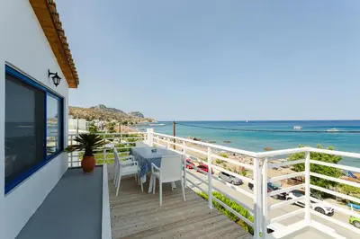 a balcony with a table and chairs and the beach at Apágkio Filoxenia in Archangelos
