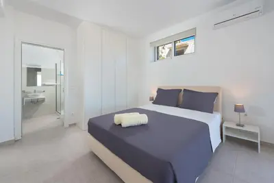 a bedroom with a large bed and a bathroom at Sea view villa with private pool Horizontes in Kalithies