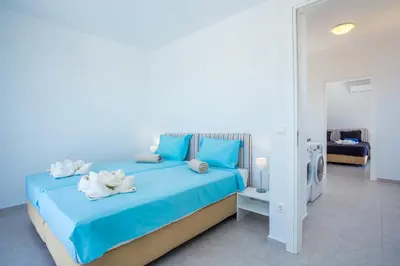 a bedroom with a blue bed with towels on it at Sea view villa with private pool Horizontes in Kalithies