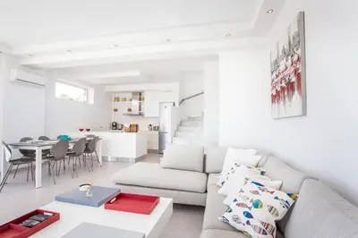 a white living room with a couch and a table at Sea view villa with private pool Horizontes in Kalithies