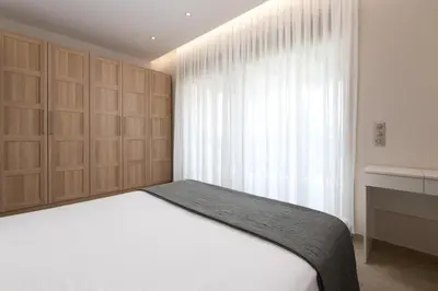 a bedroom with a white bed and a window at Aelia Luxury Apartment-with swimming pool in Afantou