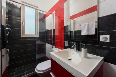 a bathroom with a white sink and a toilet at Aelia Luxury Apartment-with swimming pool in Afantou