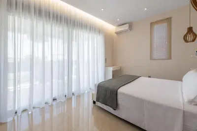 a bedroom with a bed and a large window at Aelia Luxury Apartment-with swimming pool in Afantou