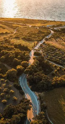a road in the middle of a field with the ocean at Kamiros Apartment in Kalavárda