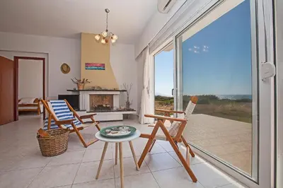 a living room with rocking chairs and a fireplace at Kamiros Apartment in Kalavárda