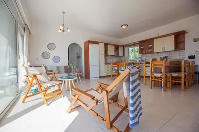 a kitchen and living room with chairs and a table at Kamiros Apartment in Kalavárda