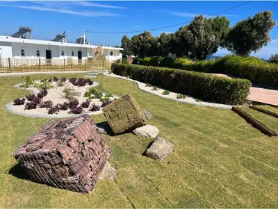 a garden with a brick structure in the grass at Kamiros Apartment in Kalavárda