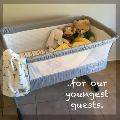 a crib with stuffed animals in it with a sign on it at Harmonia at Gennadi Court in Gennadi