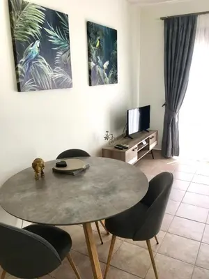 a living room with a table and chairs and a television at Harmonia at Gennadi Court in Gennadi