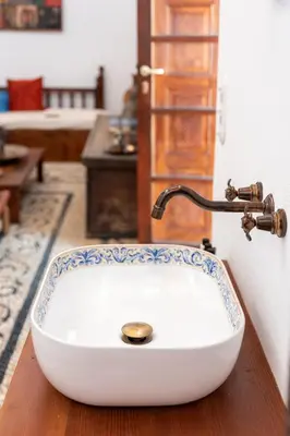 a bathroom with a white sink with a faucet at Antique Villa in Líndos