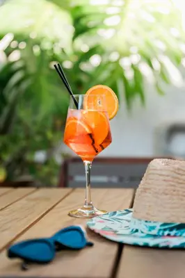 a drink in a glass with an orange slice on a table at Antique Villa in Líndos