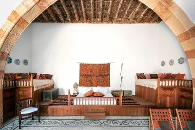 a room with two beds and a table and a chair at Antique Villa in Líndos