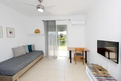 a living room with a couch and a table at Athina's Apartment in Olive Grove in Faliraki