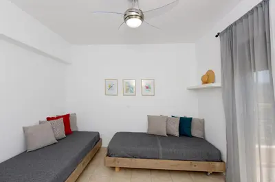 a bedroom with two beds and a window at Athina's Apartment in Olive Grove in Faliraki