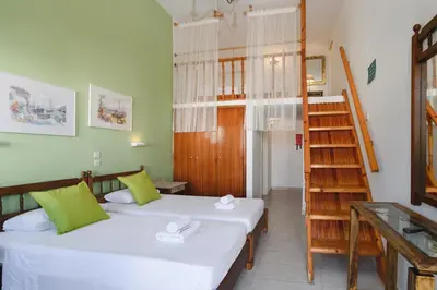 a room with two beds and a staircase in it at Aphrodite White Studios Lindos in Líndos