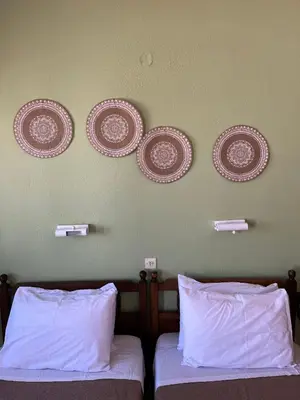 two beds in a room with plates on the wall at Aphrodite White Studios Lindos in Líndos