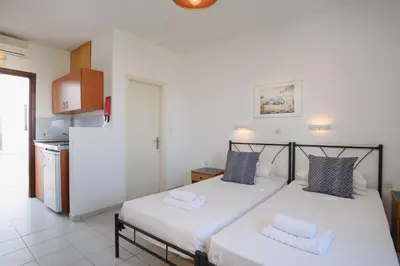 a bedroom with a large bed with two pillows at Aphrodite White Studios Lindos in Líndos