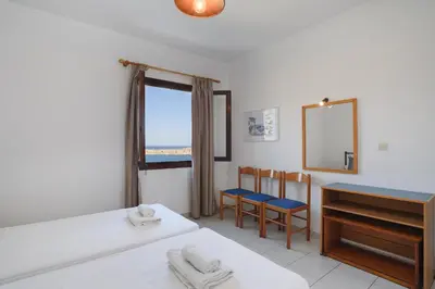 a bedroom with a bed and a desk and a mirror at Aphrodite White Studios Lindos in Líndos
